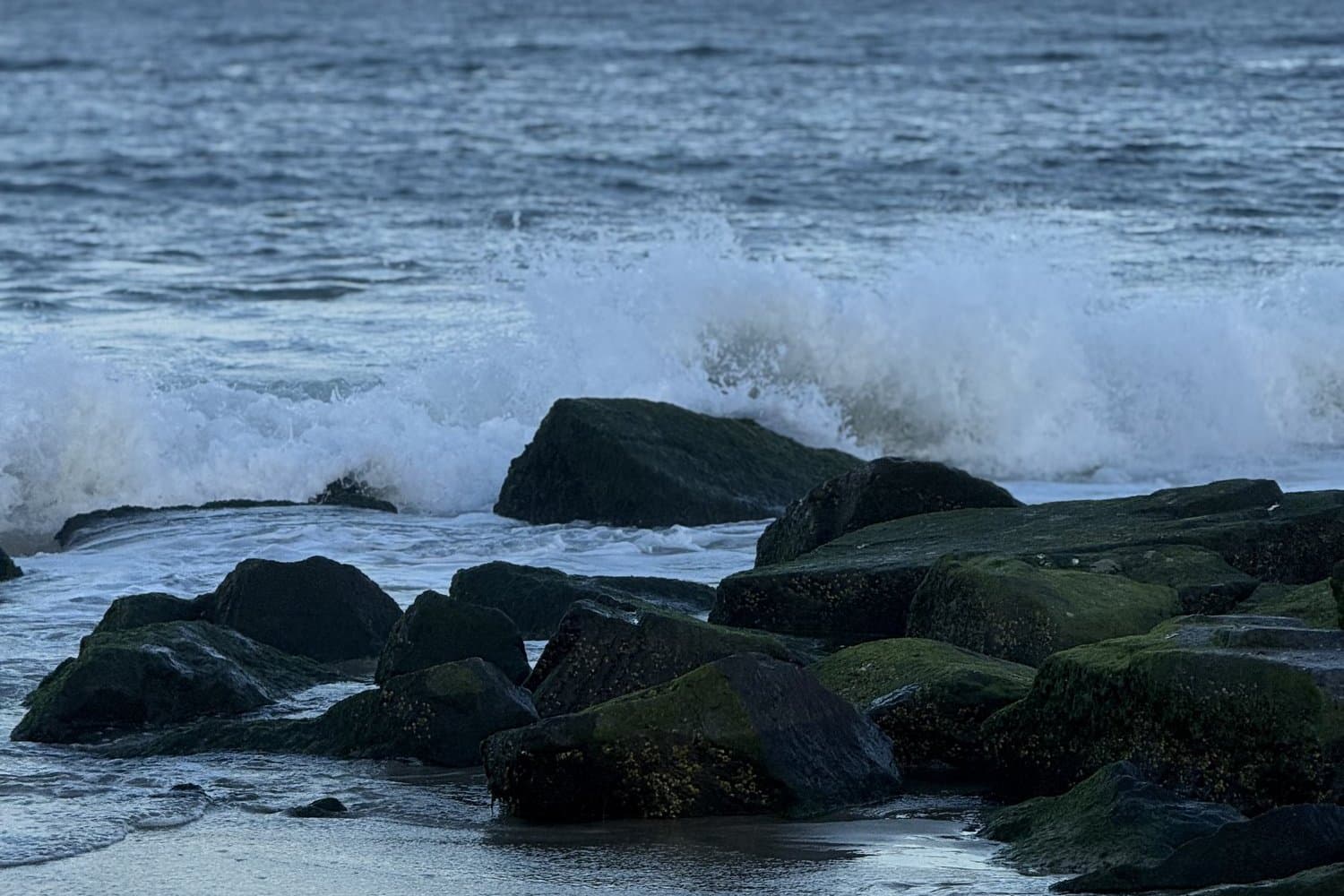 Rock jetty with a breaking wave