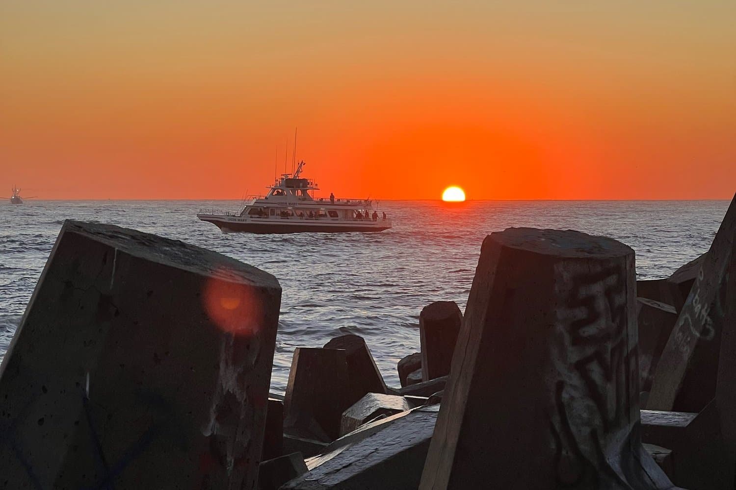 Jetty at sunset with a party boat