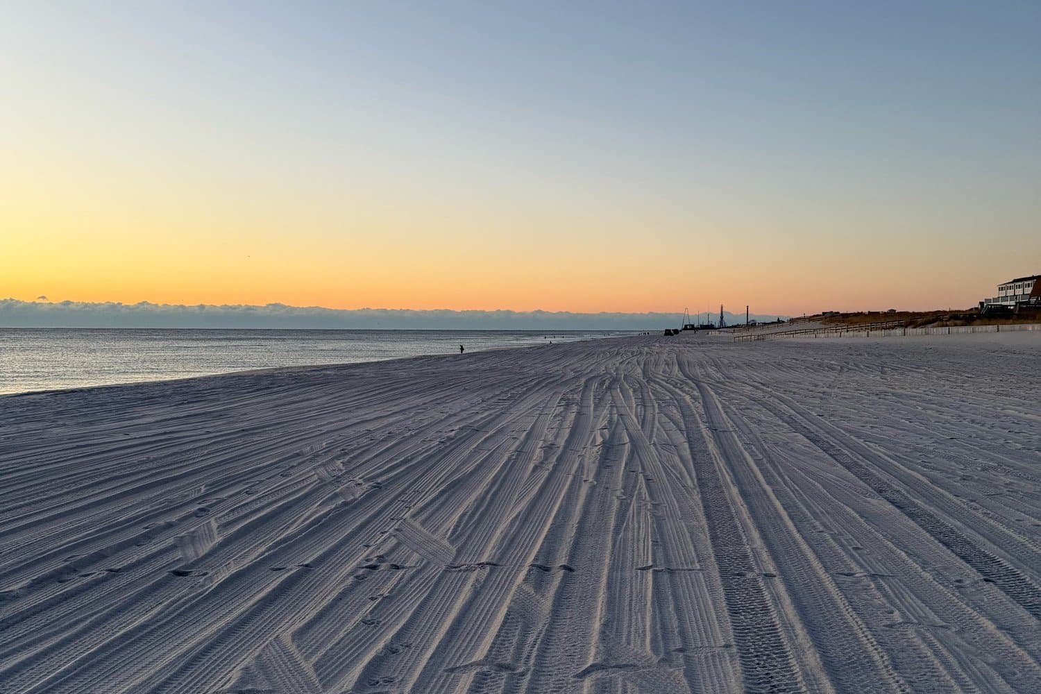 Tire-tracked beach at sunrise